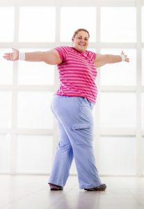 Smiling overweight woman having a sports training and looking at camera.